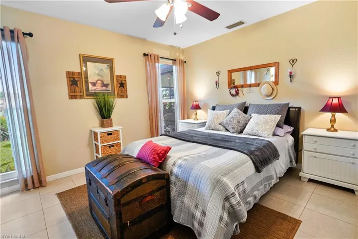 Main bedroom is a suite with a private bathroom. Neutral tiled and ceiling fan.