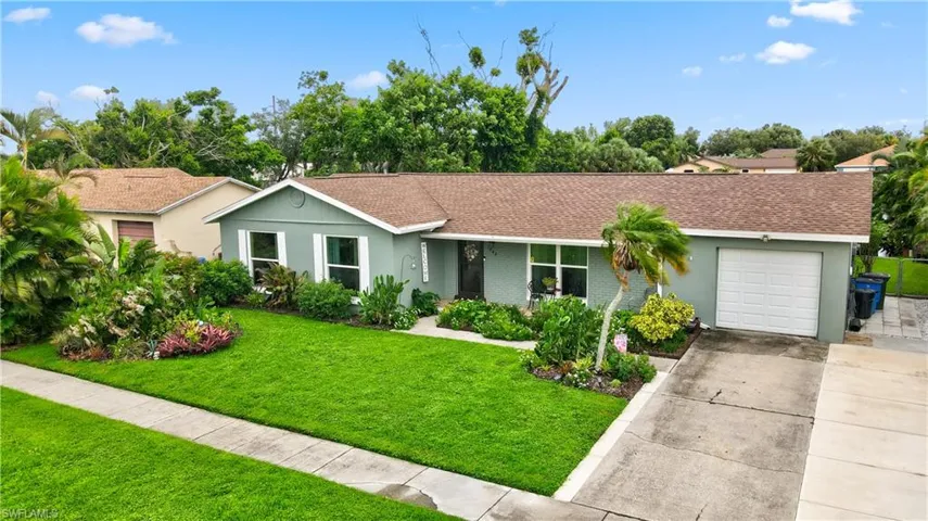 Single story home featuring a garage and a front lawn