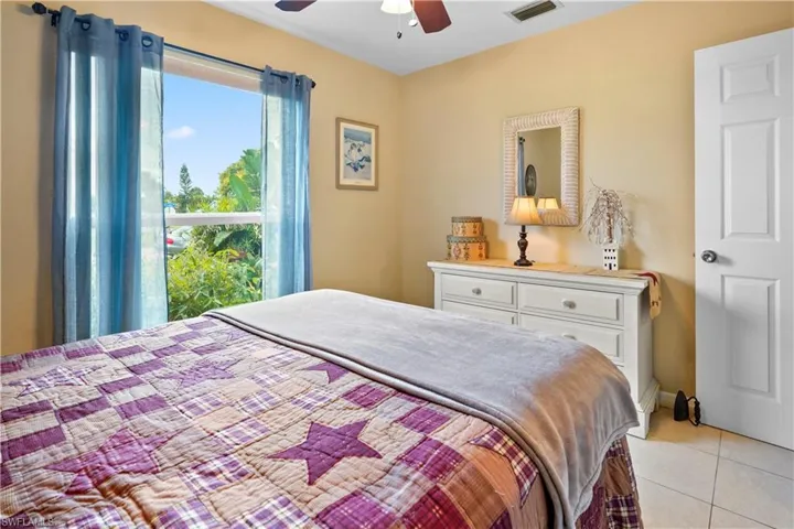 Main bedroom with light tile patterned flooring and ceiling fan