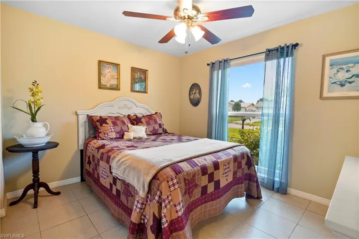 Guest bedroom featuring light tile patterned flooring and ceiling fan