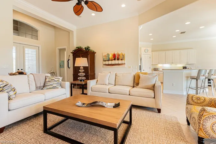 Living room with ornamental molding, light tile patterned flooring, ceiling fan, and recessed lighting