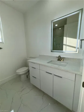 Bathroom with tile flooring, toilet, and vanity