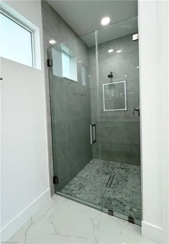 Bathroom featuring an enclosed shower and tile flooring
