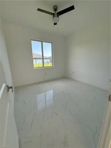 Empty room with ceiling fan and tile floors