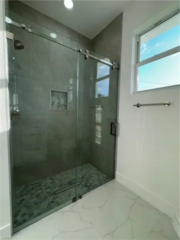 Bathroom featuring tile floors and a shower with door