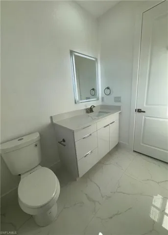 Bathroom with tile flooring, vanity, and toilet