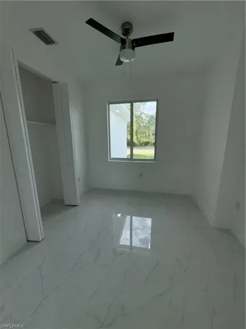 Unfurnished bedroom featuring tile flooring and ceiling fan