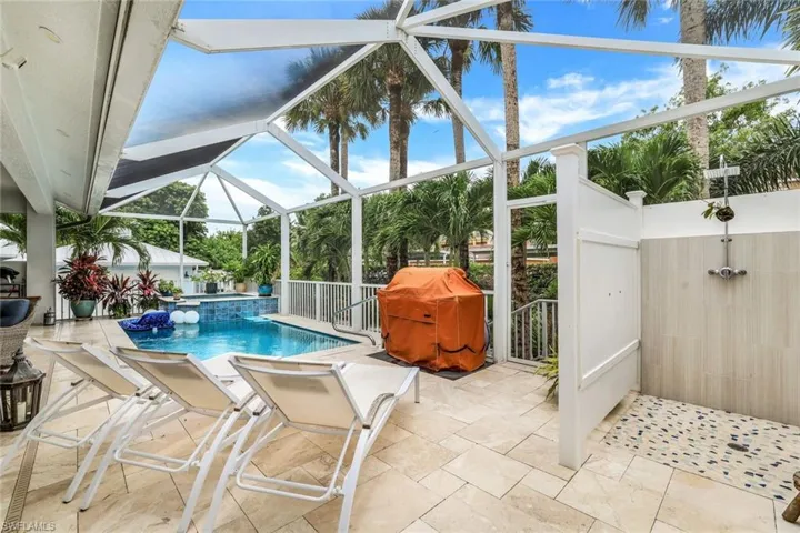 View of pool featuring an outdoor shower, a patio, screen enclosure, and a grill