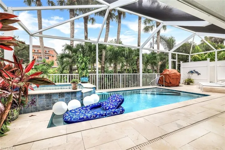 View of pool featuring a patio area and screen enclosure