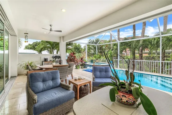 View of patio with an outdoor living space, ceiling fan, and screen enclosure