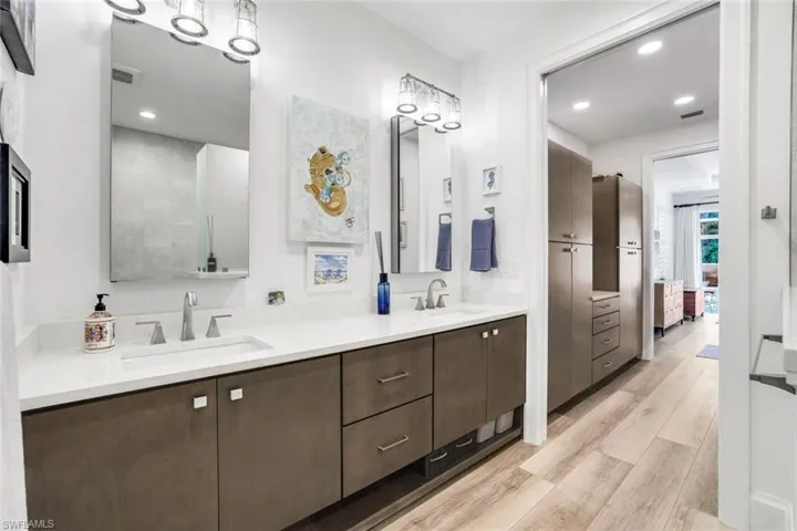 Bathroom with dual vanity and wood-type flooring