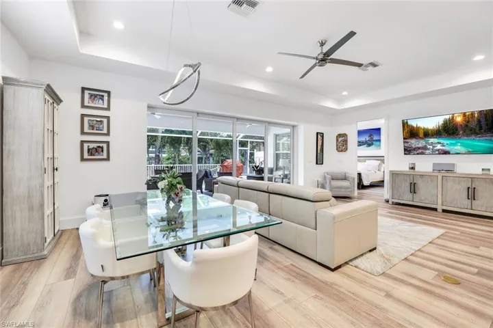 Dining room featuring ceiling fan, light wood-type flooring, and a tray ceiling