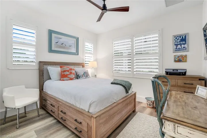 Bedroom featuring light hardwood / wood-style floors, multiple windows, and ceiling fan