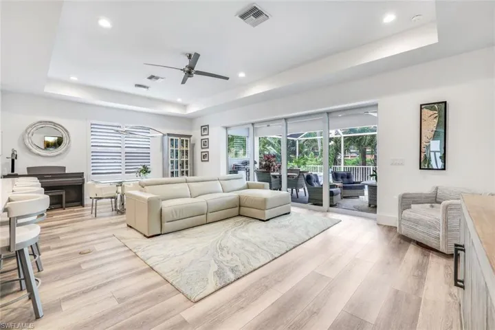 Living room featuring a tray ceiling, light hardwood / wood-style flooring, and ceiling fan