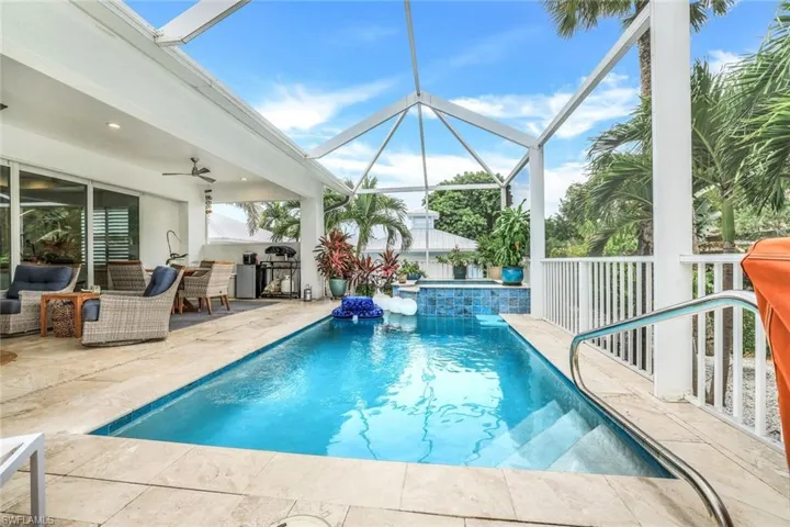 View of pool featuring an in ground hot tub, screen enclosure, a patio area, and ceiling fan