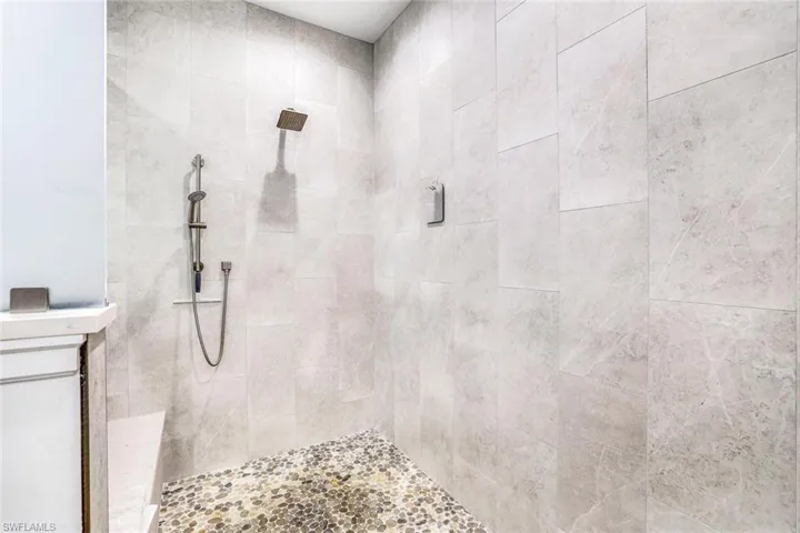 Bathroom featuring vanity and tiled shower