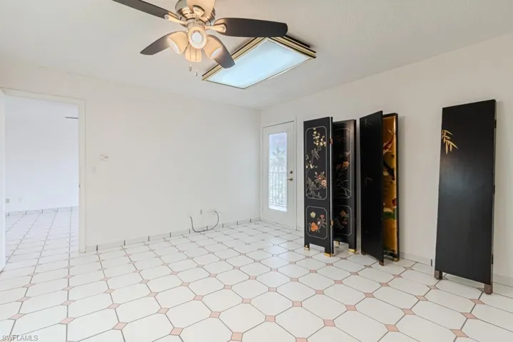 Tiled spare room featuring ceiling fan