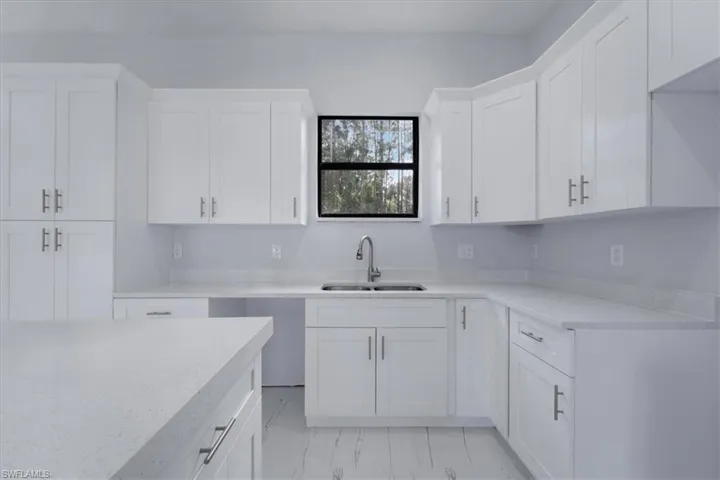 Kitchen featuring sink and white cabinets