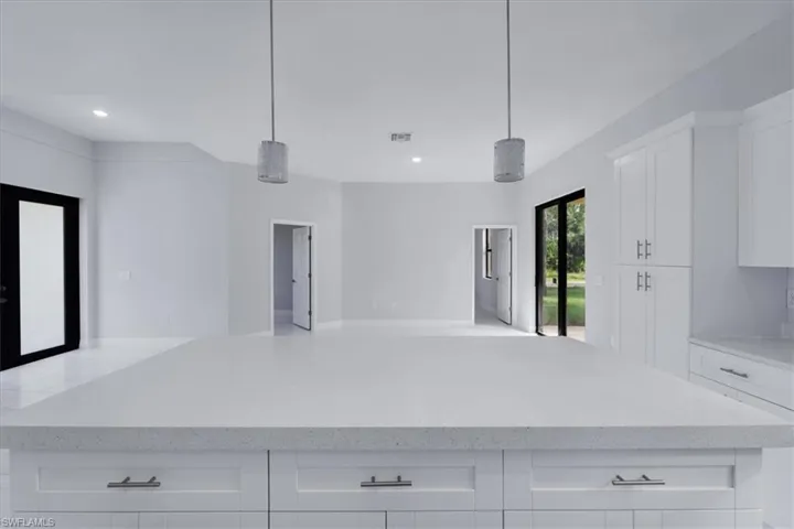 Kitchen featuring white cabinetry, a center island, and hanging light fixtures