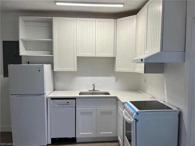 Kitchen featuring white appliances, washer / dryer, electric panel, open shelves, and light countertops