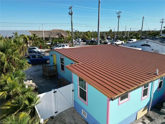 View of property exterior with fence, metal roof, crawl space, a standing seam roof, and a gate