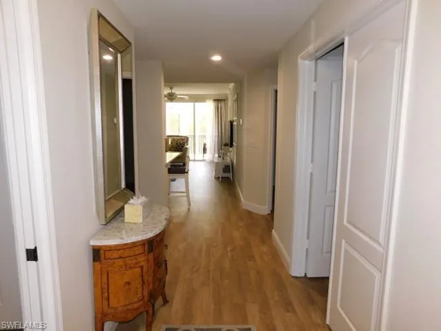 Hall featuring wood finished floors and recessed lighting