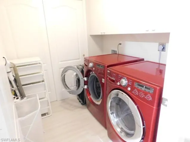 Washroom featuring washing machine and dryer and cabinet space