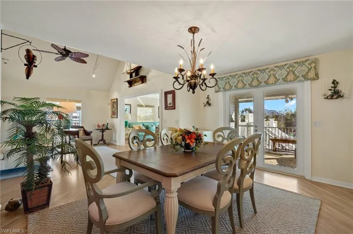 Dining room featuring vaulted ceiling, plenty of natural light, ceiling fan, and light hardwood / wood-style flooring