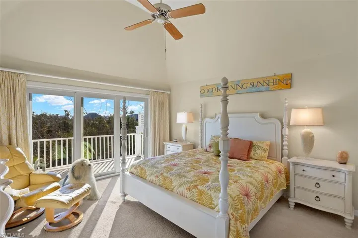 Carpeted bedroom featuring access to exterior, ceiling fan, and a high ceiling