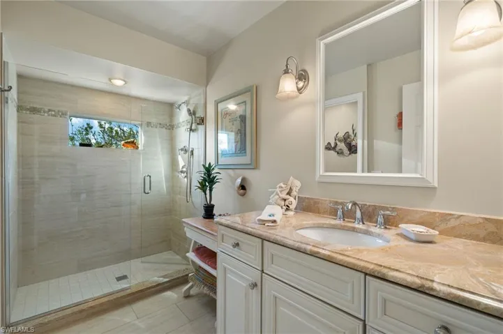 Bathroom featuring vanity and a shower with door