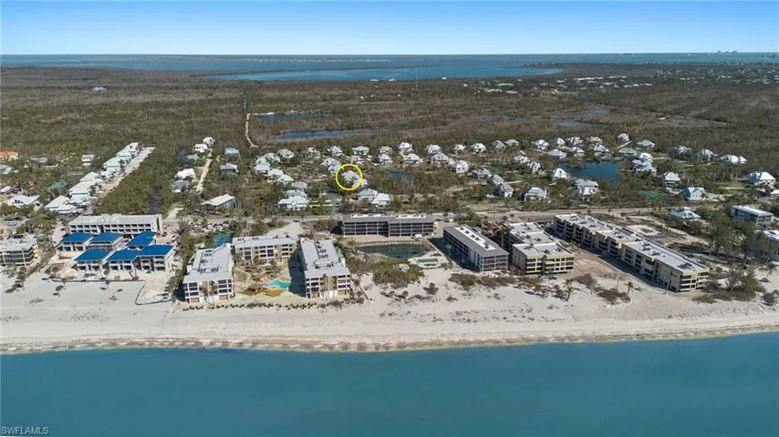 Birds eye view of property featuring a beach view and a water view