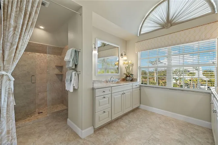 Bathroom featuring a shower with door and vanity
