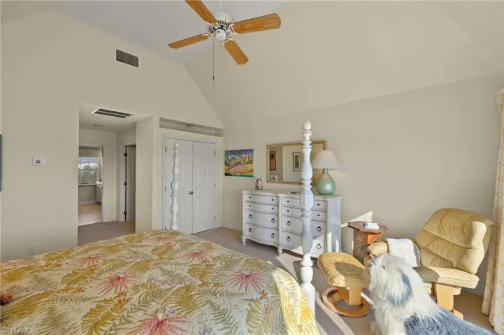 Bedroom featuring ceiling fan, light colored carpet, high vaulted ceiling, and a closet