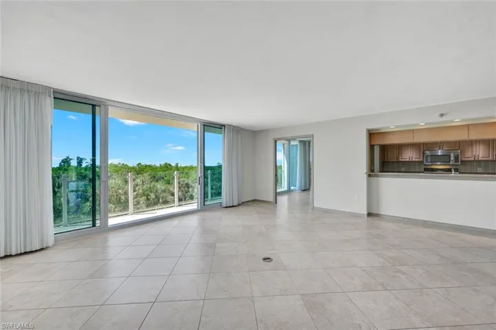Unfurnished living room with expansive windows and light tile patterned flooring