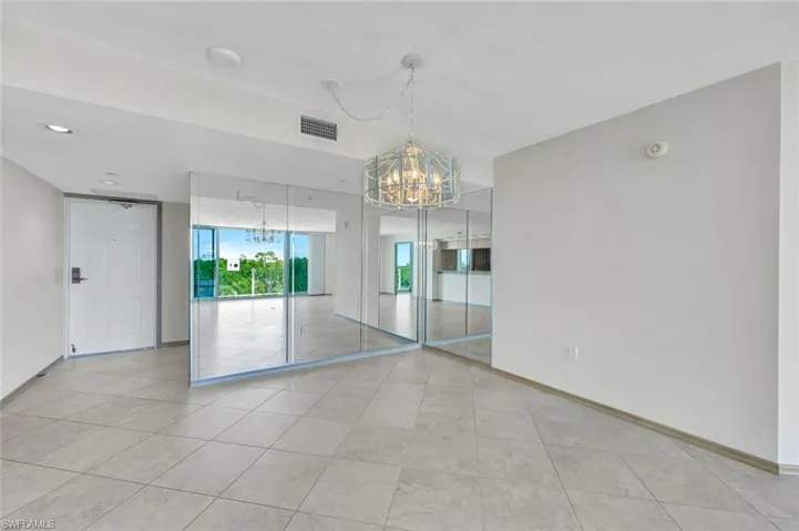Empty room featuring a chandelier and light tile patterned flooring