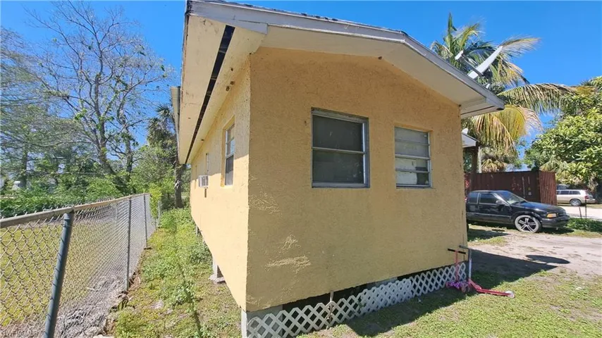 View of property exterior featuring crawl space, fence, and stucco siding