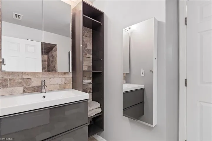 Guest Bathroom featuring visible vents, a sink, and two vanities