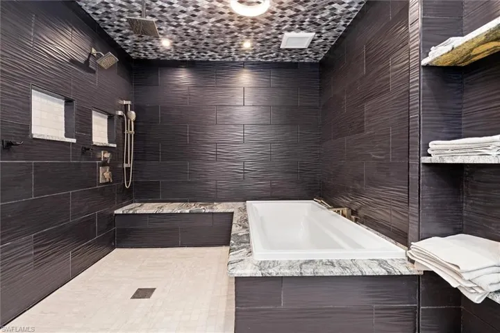 Inlaw Full bath featuring tile walls, a tile shower, and a garden tub