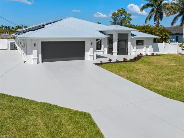 View of front of home with concrete driveway, stucco siding, an attached garage, central AC unit, and a front lawn