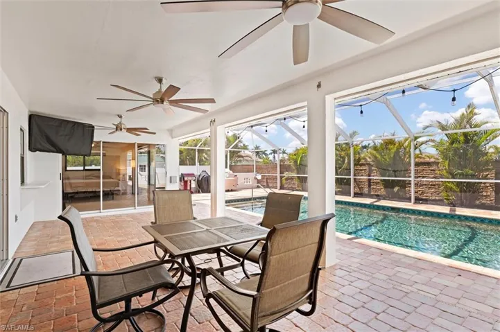Sunroom featuring a swimming pool and a ceiling fan