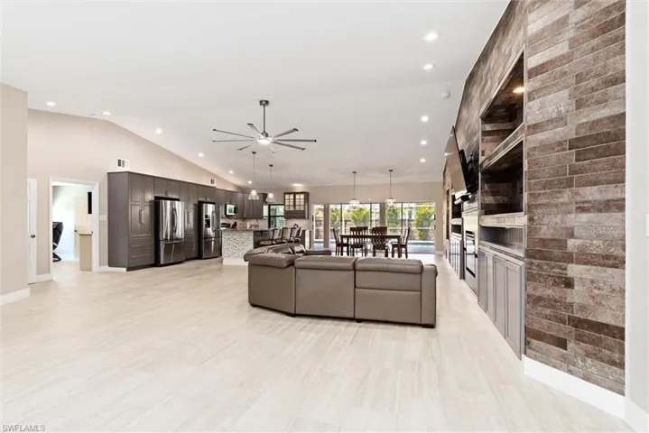 Living/Great room with high vaulted ceiling, a ceiling fan, baseboards, visible vents, and recessed lighting