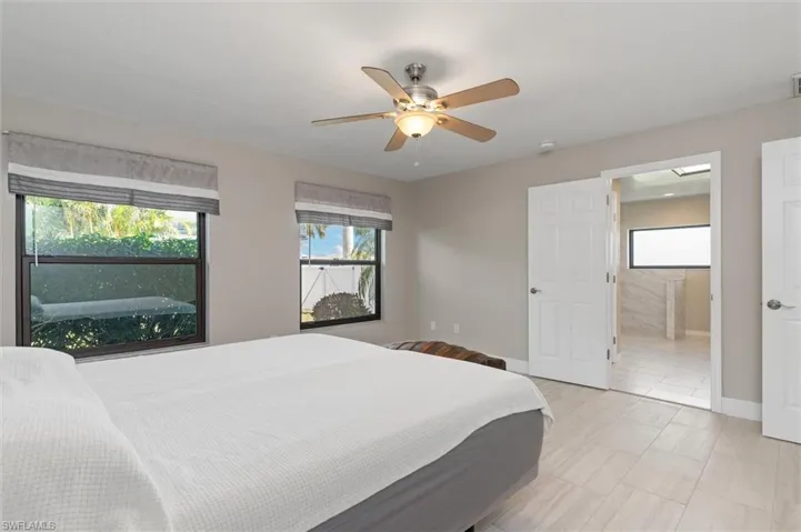 Primary Bedroom featuring a ceiling fan, ensuite bathroom, baseboards, and visible vents