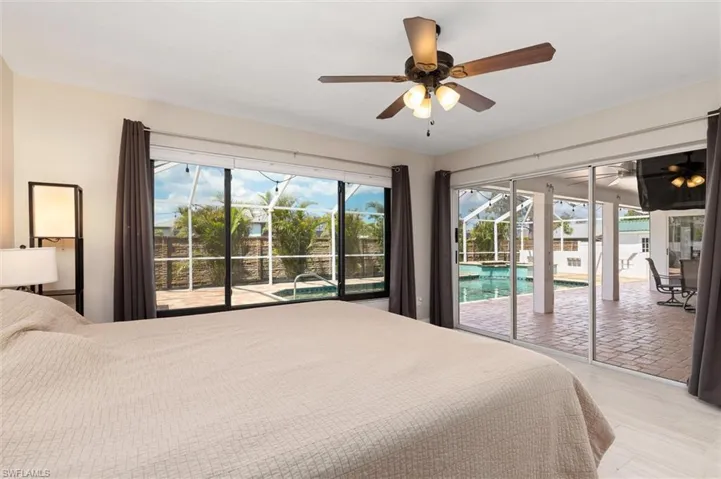 bedroom featuring access to exterior, light wood-style flooring, and a ceiling fan