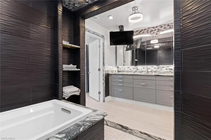 Inlaw Bathroom featuring vanity, tile walls, and a bathtub