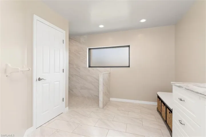 Primary Bathroom with baseboards, vanity, recessed lighting, and walk in shower