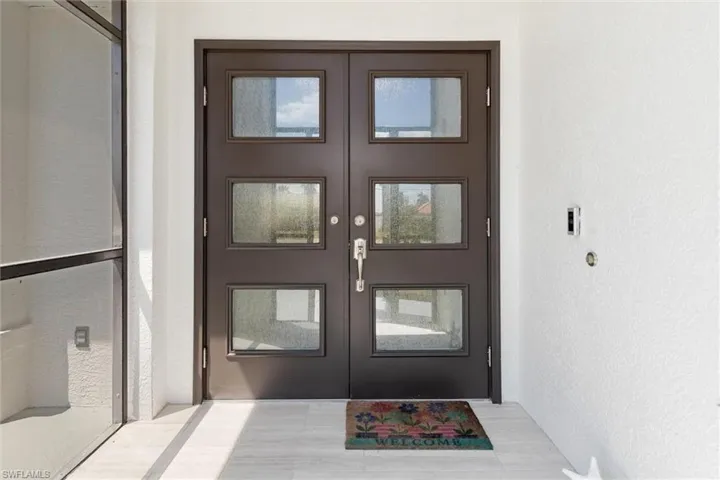 View of exterior entry featuring french doors and stucco siding