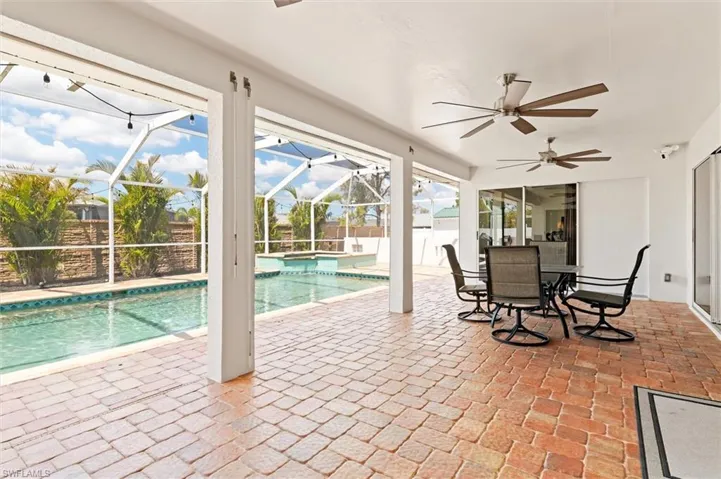 View of swimming pool featuring a patio area, a fenced in pool, a ceiling fan, fence, and a lanai