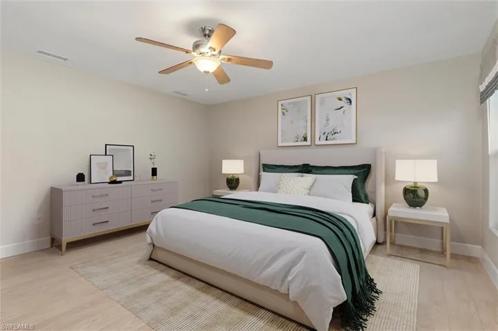 Virtually Staged Primary Bedroom featuring baseboards, light wood-style flooring, visible vents, and ceiling fan