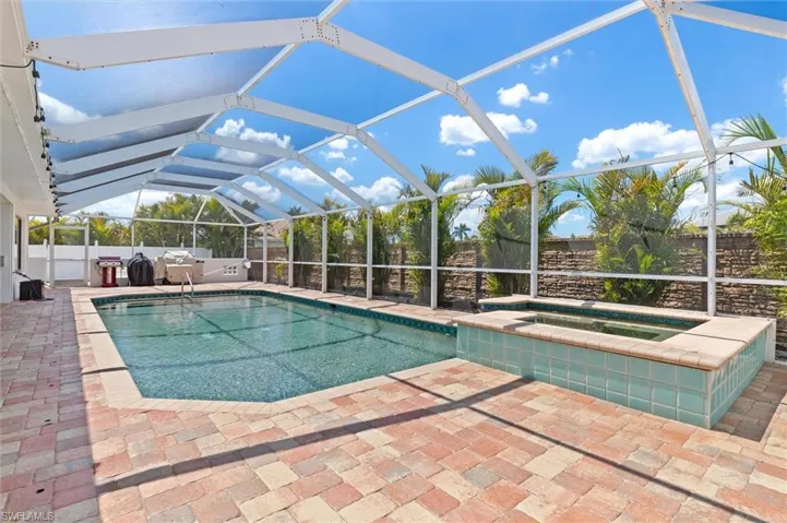 View of swimming pool with a lanai, an in ground hot tub, and a patio