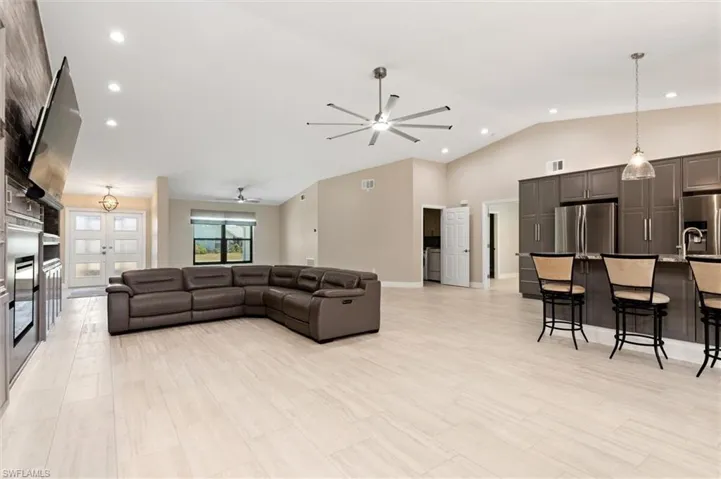 Living area featuring visible vents, ceiling fan, high vaulted ceiling, and recessed lighting